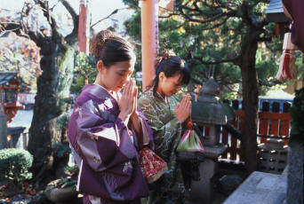 Recueillement devant l'autel d'un sanctuaire Shintô dans le quartier de Gion de Kyotô